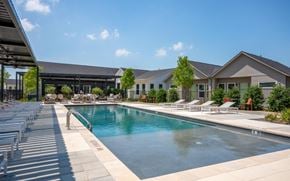 Denton apartment for rent - a swimming pool with a building in the background
