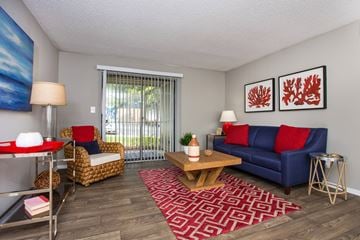 Birmingham apartment for rent - A living room with a blue couch and a red and white rug.
