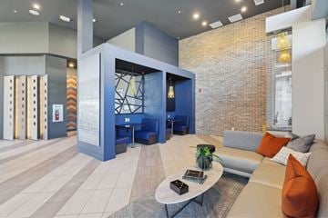 Huntsville apartment for rent - A modern living room with a blue sofa and a glass table.