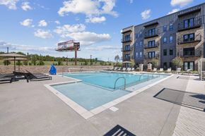 Huntsville apartment for rent - A swimming pool in front of a building with a billboard in the background.
