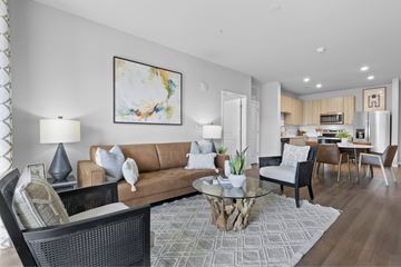 Greenville apartment for rent - A modern living room with a brown sofa and a glass coffee table.