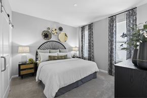 Greenville apartment for rent - A bedroom with a large bed and a mirror on the wall.