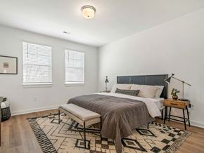 Madison apartment for rent - A bedroom with a bed, bench, and rug.