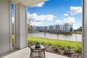 Palm Bay apartment for rent - A balcony with a table and chairs overlooking a body of water and buildings.