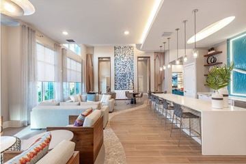 Palm Bay apartment for rent - A modern living room with a long white sofa and a long white table.