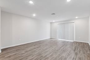 Jacksonville apartment for rent - A spacious room with wooden flooring and white walls.