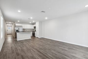 Jacksonville apartment for rent - A spacious kitchen with white cabinets and a wooden floor.