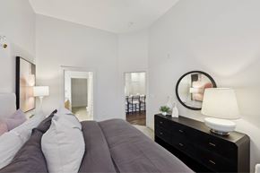 Nashville apartment for rent - A bedroom with a large bed and a mirror on the wall.