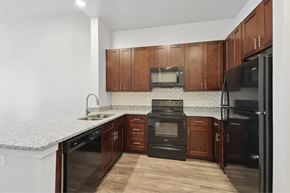 Nashville apartment for rent - A kitchen with dark wood cabinets and black appliances.