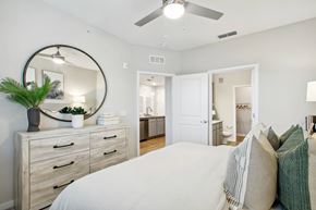 Palm Bay apartment for rent - A bedroom with a large bed, a dresser, and a mirror.