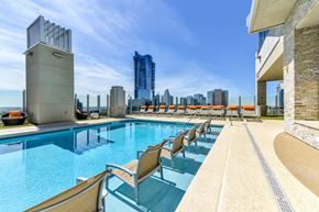 Atlanta apartment for rent - A pool with chairs and a city skyline in the background.