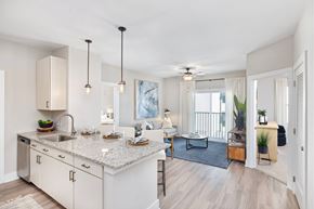 Myrtle Beach apartment for rent - A kitchen with a marble countertop and a dining area with a table and chairs.