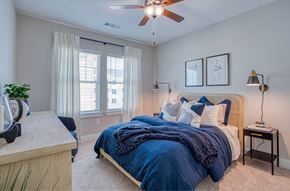 Myrtle Beach apartment for rent - A bedroom with a bed covered in a blue blanket and pillows.