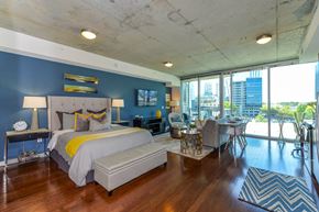 Atlanta apartment for rent - A bedroom with a large bed and a view of the city.