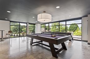 Huntsville apartment for rent - A pool table is in the middle of a room with a concrete floor and ceiling.