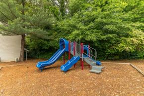 Decatur apartment for rent - A playground with a blue slide and red railings.