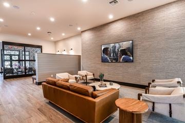 Miami apartment for rent - A modern living room with a brown sofa and a painting on the wall.