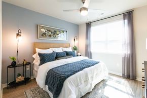 Gainesville apartment for rent - A bedroom with a large bed and a ceiling fan.