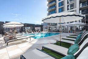 Nashville apartment for rent - A sunny day at the pool with lounge chairs and umbrellas.