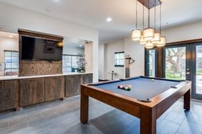 Houston apartment for rent - A pool table in a room with a television and a fireplace.