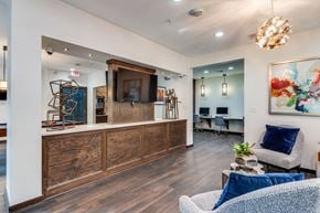 Houston apartment for rent - A living room with a wooden entertainment center and a grey sofa.