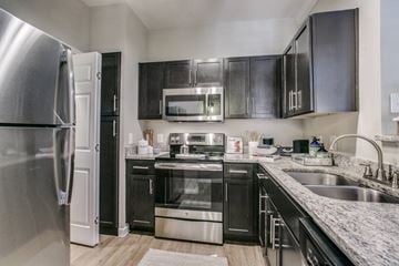 Houston apartment for rent - A modern kitchen with black cabinets and stainless steel appliances.