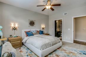 Houston apartment for rent - A bedroom with a large bed and a ceiling fan.