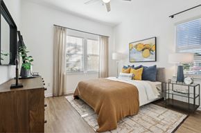 Sarasota apartment for rent - A bedroom with a bed, a dresser, and a ceiling fan.