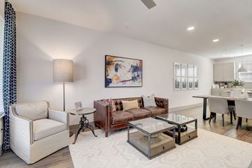 Farmers Branch apartment for rent - A modern living room with a white sofa, a glass coffee table, and a painting on the wall.