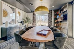 Dallas apartment for rent - A modern dining room with a round wooden table and grey chairs.