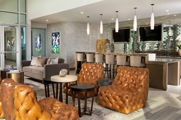 Frisco apartment for rent - A living room with brown leather chairs and a grey couch.