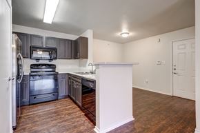 Dallas apartment for rent - A kitchen with a white refrigerator and a black stove top oven.