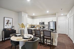 Prosper apartment for rent - A modern kitchen with a dining table set for four.