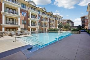 Ft. Worth apartment for rent - A swimming pool is surrounded by apartment buildings.