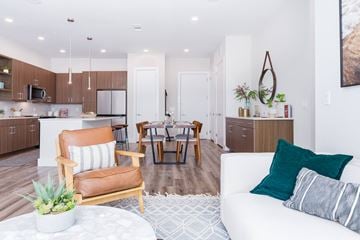 Plano apartment for rent - A modern living room with a white couch and a wooden chair.