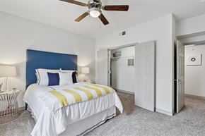 Austin apartment for rent - A bedroom with a large bed and a ceiling fan.