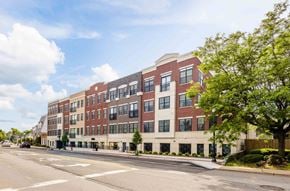 Ridgewood apartment for rent - A street view of a multi-story building with a clear sky above.