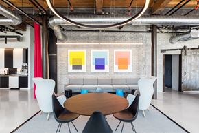 Charlestown apartment for rent - A modern dining room with a round wooden table surrounded by white chairs.