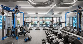 Charlestown apartment for rent - A gym with a variety of equipment including dumbbells, weight plates, and a leg press machine.