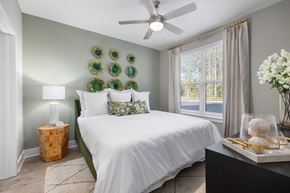Summerville apartment for rent - A bedroom with a white bed and green accents.