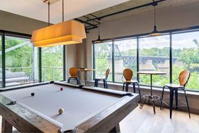 Haverhill apartment for rent - A pool table is in the middle of a room with a view of a bridge outside the window.
