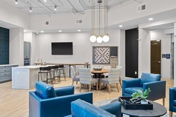 Greenville apartment for rent - A modern living room with blue chairs and a television.