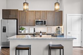 Greenville apartment for rent - A kitchen with a white refrigerator and wooden cabinets.