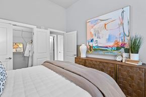 Greenville apartment for rent - A bedroom with a large bed and a painting on the wall.