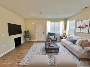 Northampton apartment for rent - Pet-Friendly Garden-Style Apartments in Northampton, PA- Residences at Willow Ridge - A Living Room with Large Windows, Coffee Table, and Mounted Flat Screen TV.