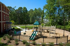 Fairfax apartment for rent - A playground with a green slide and a red building in the background.