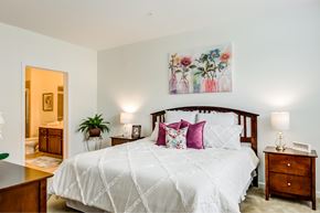 Mt. Laurel apartment for rent - A bedroom with a large bed and a painting above it.