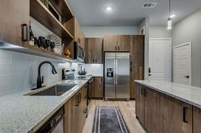 Dallas apartment for rent - A kitchen with wooden cabinets at The Academic in Dallas Texas