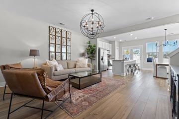 Summerville apartment for rent - A modern living room with a brown leather chair and a glass coffee table.