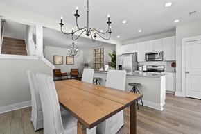 Summerville apartment for rent - a dining room and kitchen with white cabinets and a wooden table